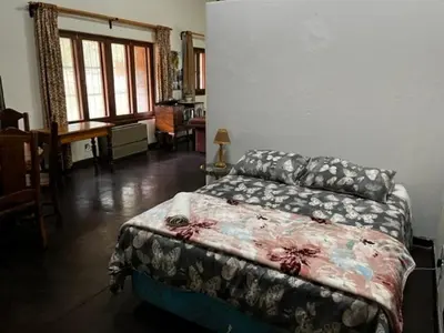 a bedroom with a bed and a desk in a room at Soutpansberg Lodge Louis Trichardt