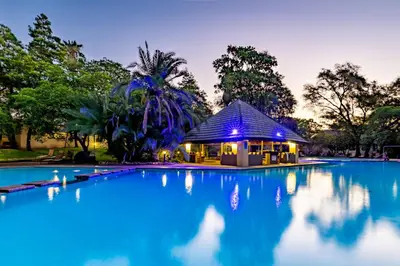 a swimming pool with a gazebo at night at Sanbonani Resort Chalets in Hazyview