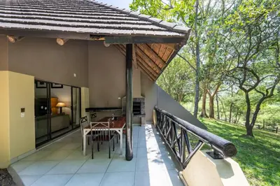 a balcony of a house with a table and chairs at Sanbonani Resort Chalets in Hazyview