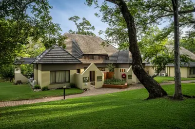 a house with a green yard at Sanbonani Resort Chalets in Hazyview