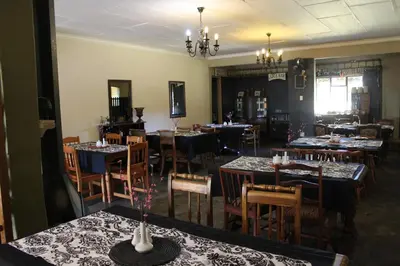 a restaurant with tables and chairs in a room at Makarios Lodge in Polokwane
