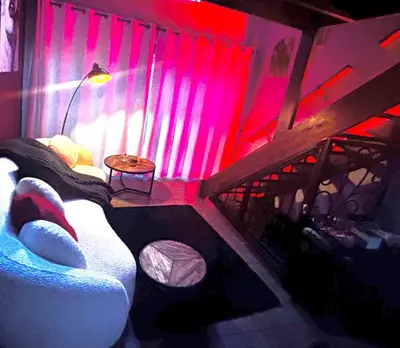a room with a bed and a red light at The KinkyKabin in Sandton