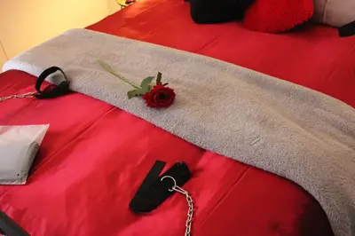 a red bed with a chain on top of it at The KinkyKabin in Sandton