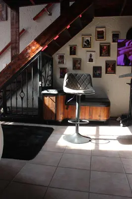 a chair sitting in a room with a staircase at The KinkyKabin in Sandton
