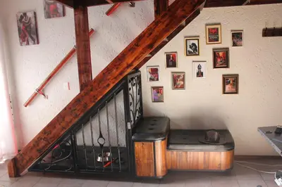 a staircase with a bench next to a wall with pictures at The KinkyKabin in Sandton