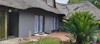 a cat sitting on a table in front of a house at Casa LaMich Garden Venue and Spa in Midrand