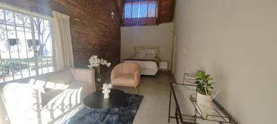 a living room with a bed and a couch and a table at Casa LaMich Garden Venue and Spa in Midrand