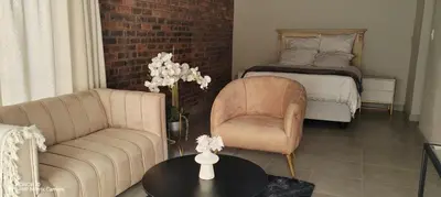 a living room with a bed and a couch and a table at Casa LaMich Garden Venue and Spa in Midrand
