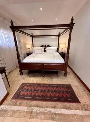 a bedroom with a large bed with a wooden frame at Concordia Boutique Venue in Midrand