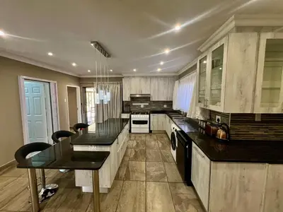 a large kitchen with black counter tops and appliances at Antelope Farm Events in Pretoria