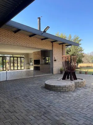 a patio with two wooden chairs in front of a building at Antelope Farm Events in Pretoria