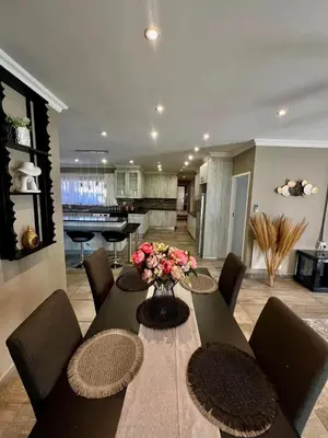 a dining room table with chairs and a vase of flowers at Antelope Farm Events in Pretoria