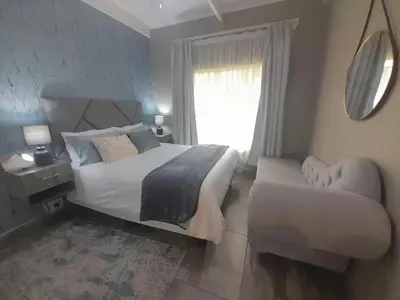 a bedroom with a large bed and a window at Antelope Farm Events in Pretoria