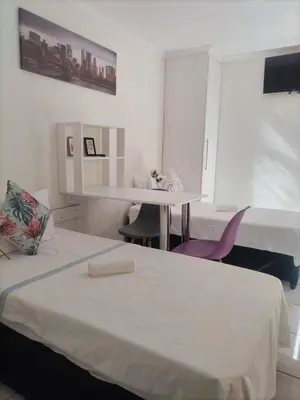 a room with a bed and a desk and a table at C-Rane Lodge 2 in Phalaborwa