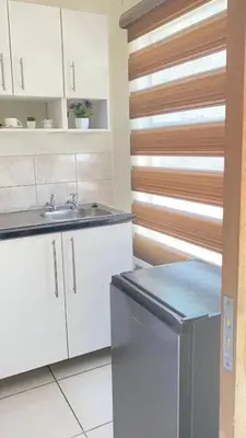 a kitchen with white cabinets and a sink at C-Rane Lodge 2 in Phalaborwa