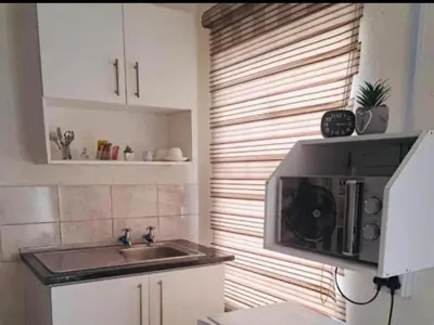 a kitchen with a sink and a microwave at C-Rane Lodge 2 in Phalaborwa