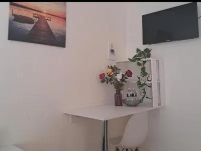 a white table with a vase of flowers on it at C-Rane Lodge 2 in Phalaborwa