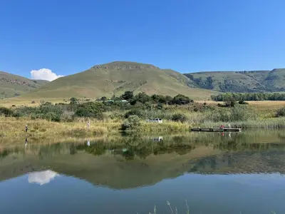 a boat on a lake with mountains in the background at Wagenbietjieshoek Wilgekraal Farmhouse in Lydenburg