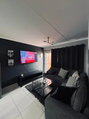 a living room with a couch and a flat screen tv at Luxury Apartment in Mbombela, Nelspruit Mpumalanga in Boschrand