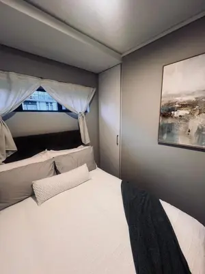 a bedroom with a large white bed with a window at Luxury Apartment in Mbombela, Nelspruit Mpumalanga in Boschrand
