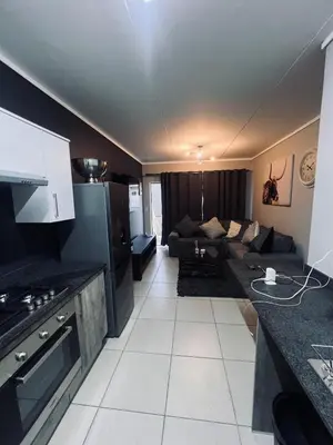 a kitchen and a living room with a couch at Luxury Apartment in Mbombela, Nelspruit Mpumalanga in Boschrand