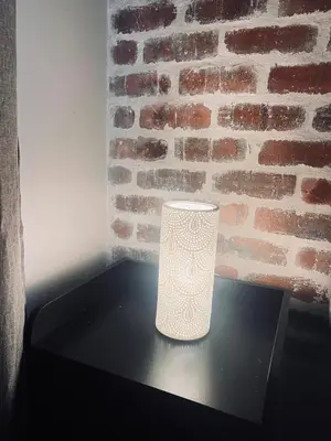 a white vase sitting on a table in front of a brick wall at Luxury Apartment in Mbombela, Nelspruit Mpumalanga in Boschrand