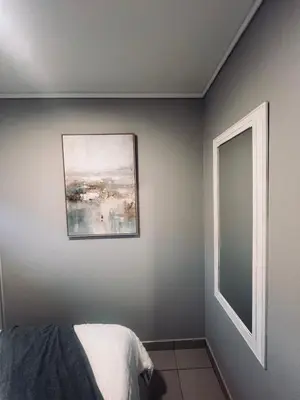 a bedroom with a painting on the wall and a bed at Luxury Apartment in Mbombela, Nelspruit Mpumalanga in Boschrand