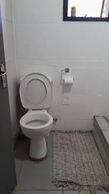 a bathroom with a toilet and a rug at Comfy at Sosha in Soshanguve
