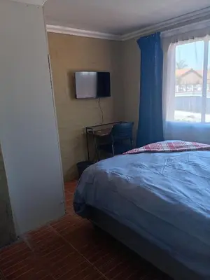 a bedroom with a bed and a window and a television at Comfy at Sosha in Soshanguve