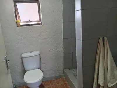 a bathroom with a toilet and a window and a shower at Comfy at Sosha in Soshanguve