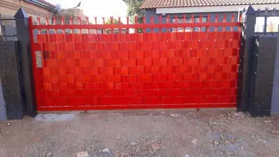 a red fence in front of a house at Comfy at Sosha in Soshanguve