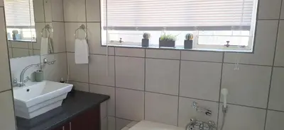 a bathroom with a sink and a window at Chrysantimum Guest Apartment in Thabazimbi