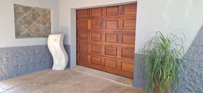 a wooden garage door with a plant next to it at Chrysantimum Guest Apartment in Thabazimbi