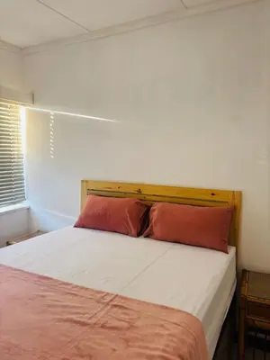 a bedroom with a bed with a red pillow at The Secret Location in Pretoria