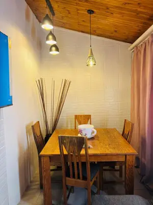 a wooden table with chairs and a bowl on it at The Secret Location in Pretoria