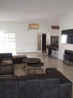 a living room with a couch and a table at Pecanwood Villa with lake view in Hartbeespoort