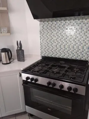 a stove in a kitchen with a tiled wall at Pecanwood Villa with lake view in Hartbeespoort