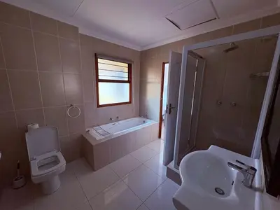 a bathroom with a tub and a toilet and a sink at Pecanwood Villa with lake view in Hartbeespoort