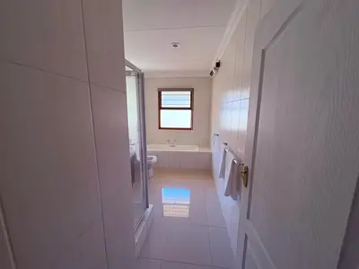 a white bathroom with a toilet and a window at Pecanwood Villa with lake view in Hartbeespoort