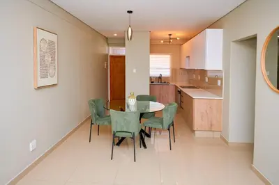 a dining room and kitchen with a table and chairs at La Genèse - S507 at Glen Park in Pretoria