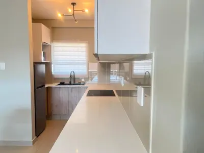 a kitchen with white cabinets and a white counter top at La Genèse - S507 at Glen Park in Pretoria