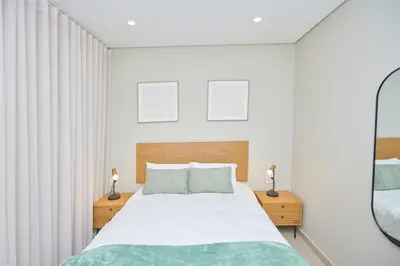 a bedroom with a large bed and a mirror at La Genèse - S507 at Glen Park in Pretoria
