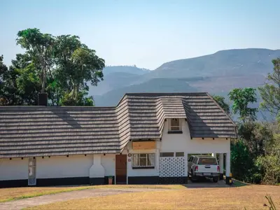 a house with a truck parked in front of it at Mount Sheba Rainforest & Resort in Pilgrimʼs Rest