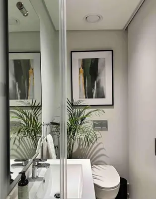 a bathroom with a toilet and a sink and a mirror at Explore Ellipse - Emerald Studio in Midrand