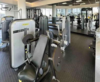 a gym with a row of treadmills and machines at Explore Ellipse - Emerald Studio in Midrand