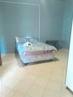 a bed in a room with a tiled floor at Twala trails lodge in Midrand