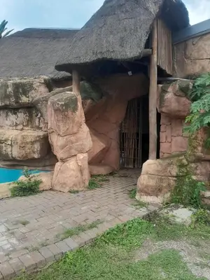 a stone house with a straw roof at Twala trails lodge in Midrand