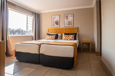 a bedroom with a large bed and a window at Carousel Eco Estate in Temba