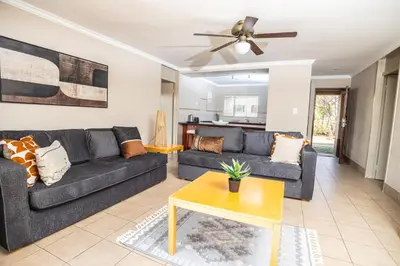 a living room with a couch and a table at Carousel Eco Estate in Temba