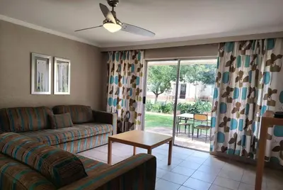 a living room with a couch and a table at Carousel Eco Estate in Temba